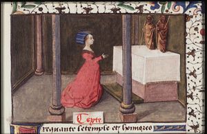 Cassandra kneels before two statues of gods in a temple