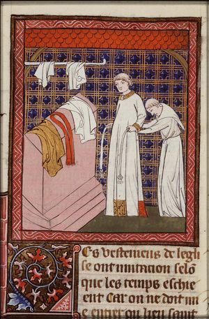 A priest getting dressed before celebrating the Mass