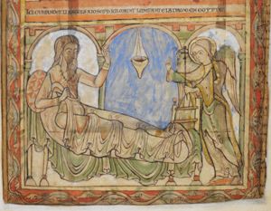an angel, standing at Joseph's feet, stretches both hands forward, making a speaking gesture with the right, and shows(?) a cross, held in the left; Joseph, sitting upright in bed, pulling up the sheet with his right hand, raises his left in gesture of speech; architectural setting, oil-lamp.