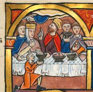 king Belshazzar, behind a rectangular table, turns his head to his right, looking upward while raising his right hand in a pointing gesture; with his left, stretched forward across the table he accepts a cup which is handed to him by a servant kneeling on one knee and holding the cup with both hands forward; to the king's right: the queen who brings a piece of food to her mouth with her right hand; behind the queen a man stretches his right hand forward, taking a piece of bread(-roll?) from the table; to the king's left, two men: one holds a cup in front of his chest, the other a piece of bread(?), while stretching his left hand forward, taking a cup; a hand appears from the sky, writing on the wall; architectural setting.