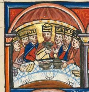 king Ahasuerus is seated behind a sigma-shaped table with his princes; he is holding a cup with his right hand in front of his chest and raises his left with the palm in front view; two of the princes stretch a hand forward, touching dishes with food; one of them brings a piece of food to his mouth; bread-rolls(?) and bread on the table; architectural setting with velum.