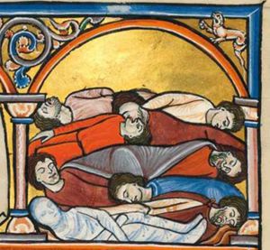 the corpses of nine men killed by the plague are lying on top of each other; one of them with his arms crossed, in a shroud; architectural setting.