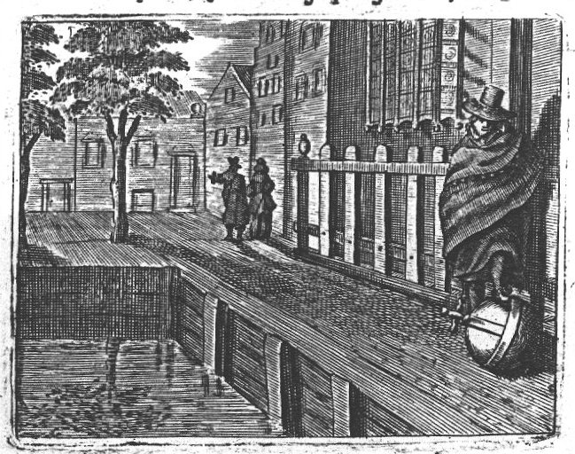 Man with his foot on an orb on a canal street; man and woman talking in the distance.