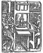 Printing shop with three men: a printer and a type setter(?) seated at a lectern, pointing at the copy in front of him with a compositor's stick, and one man holding ink balls; books on a shelf; 'Hausmarke' and initials "T.B."(?)