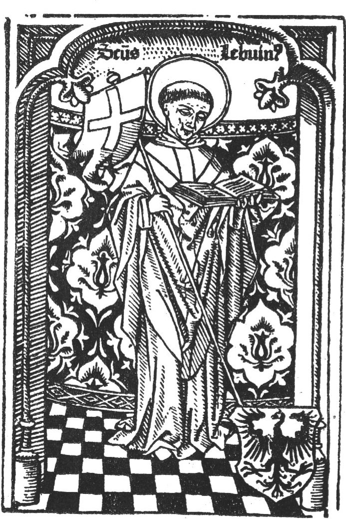 St. Lebuin standing under an arch (in an apse?), in front of a curtain or mural painting, holding a cross staff with banner and an open book; coat of arms of Deventer at his feet