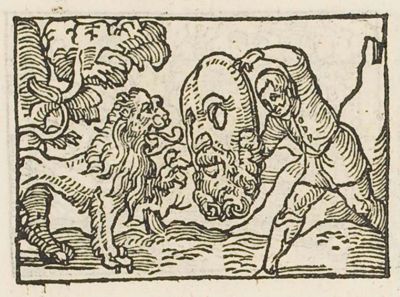 A man trying to frighten a lion with a large mask