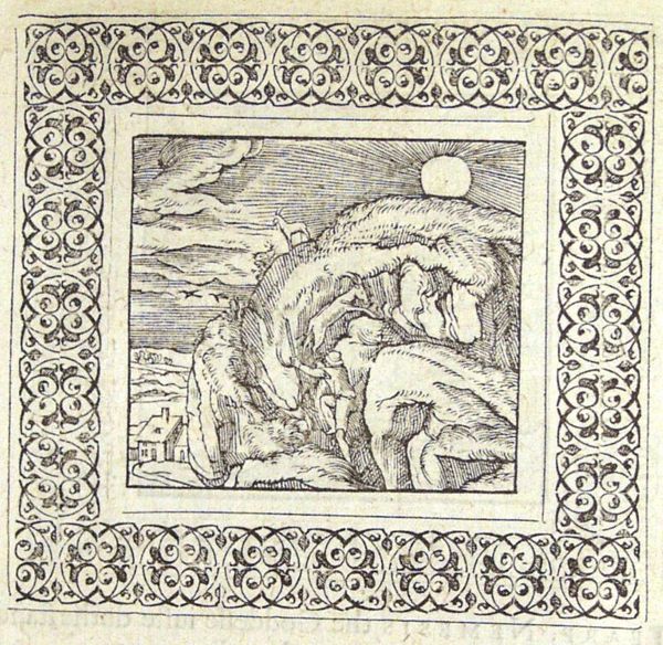 A man is climbing a mountain upon which snow lies that does not melt in the sun
