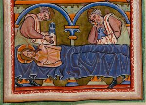 Christ lying on the stone of unction, his body covered with a cloth; Joseph of Arimathea and Nicodemus stand behind it, both with their head bent forward, wearing a Jew-hat(?) and holding an ointment-jar in a covered hand with a cloth over their shoulder; one of them holds his hand against his head; architectural setting.